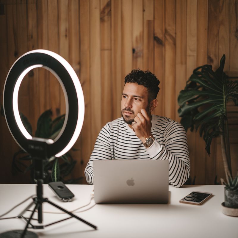 Criador de conteúdo com ring light e laptop gravando em home studio